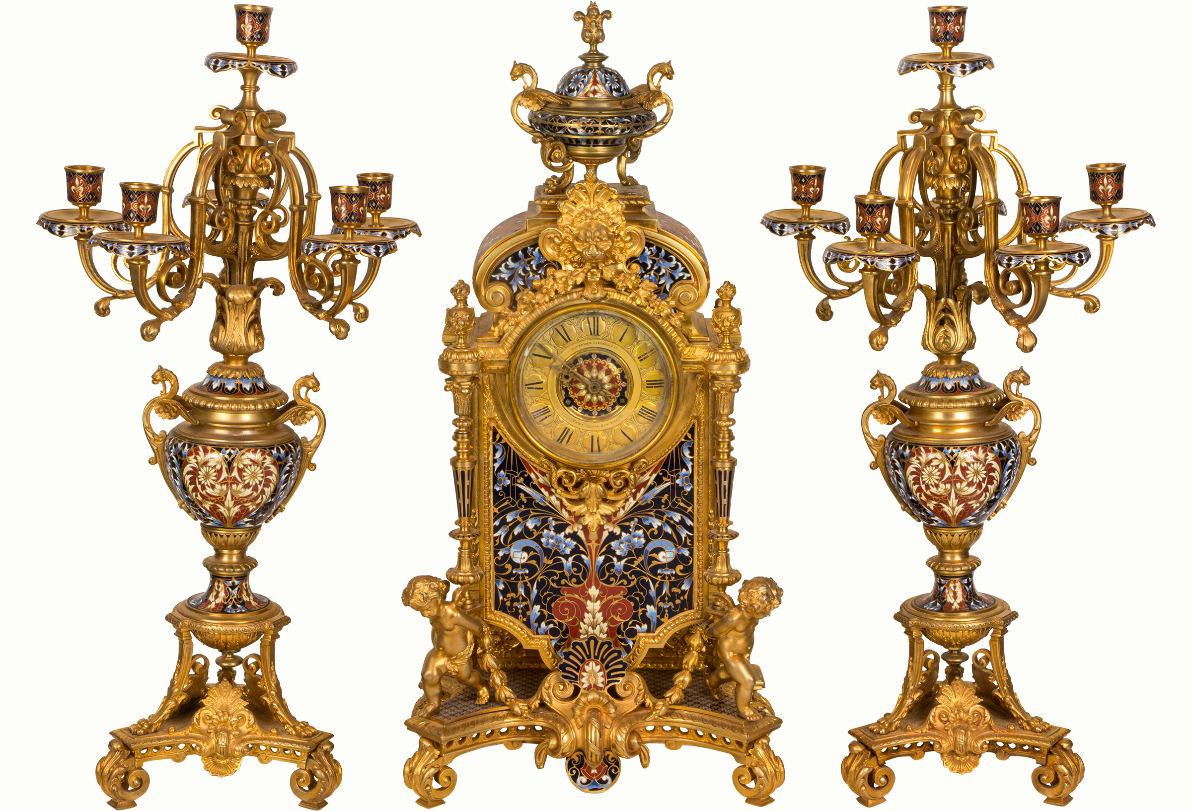 A fine French champlevé enamel and gilt bronze clock garniture, retailed by Schneider, Campbell & Co, Union Square, New York.