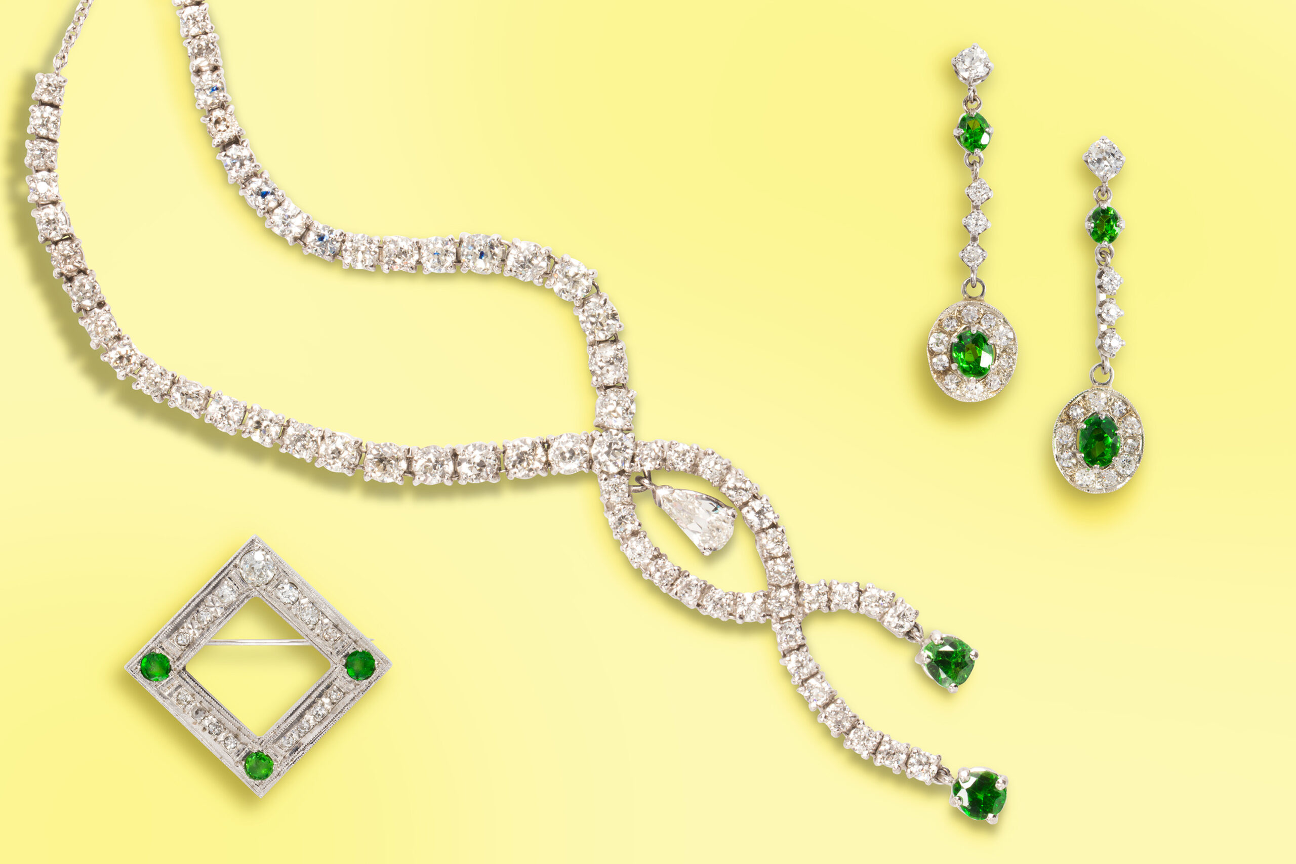 From Left to Right: A diamond, tsavorite garnet and 18k white gold brooch. Estimate: $600–$800; A diamond, tsavorite garnet and 18k white gold necklace. Estimate: $7,000–$10,000; A pair of diamond, tsavorite garnet and 18k white gold earrings. Estimate: $700–$1,000