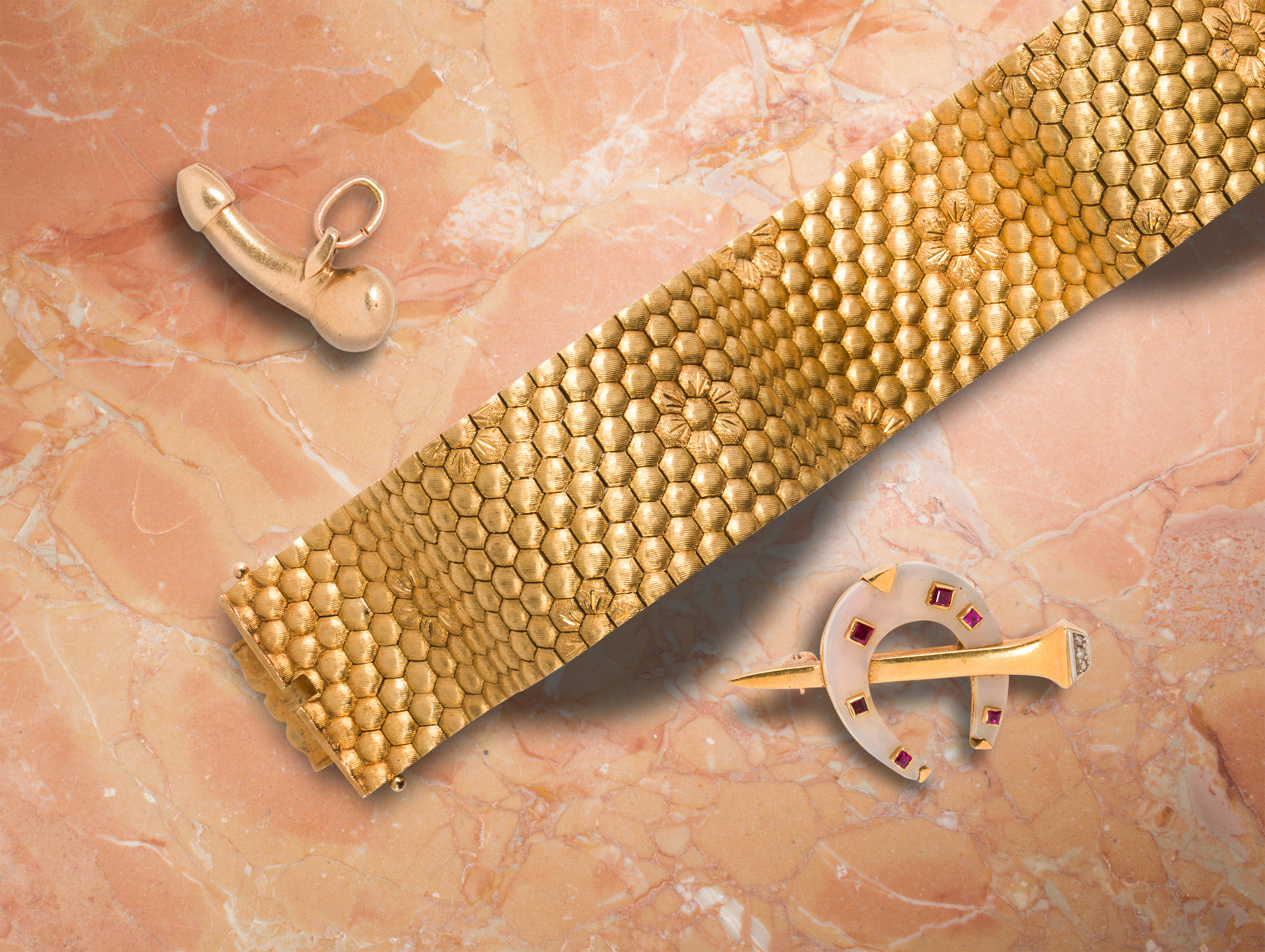 <b>From Left to Right:</b> A 14k gold charm. <b>Estimate: $300–$500</b>; An 18k gold strap bracelet. <b>Estimate: $4,000–$6,000</b>; A Cartier France ruby, diamond, frosted rock crystal and 18k gold brooch. <b>Estimate: $2,000–$3,000</b>